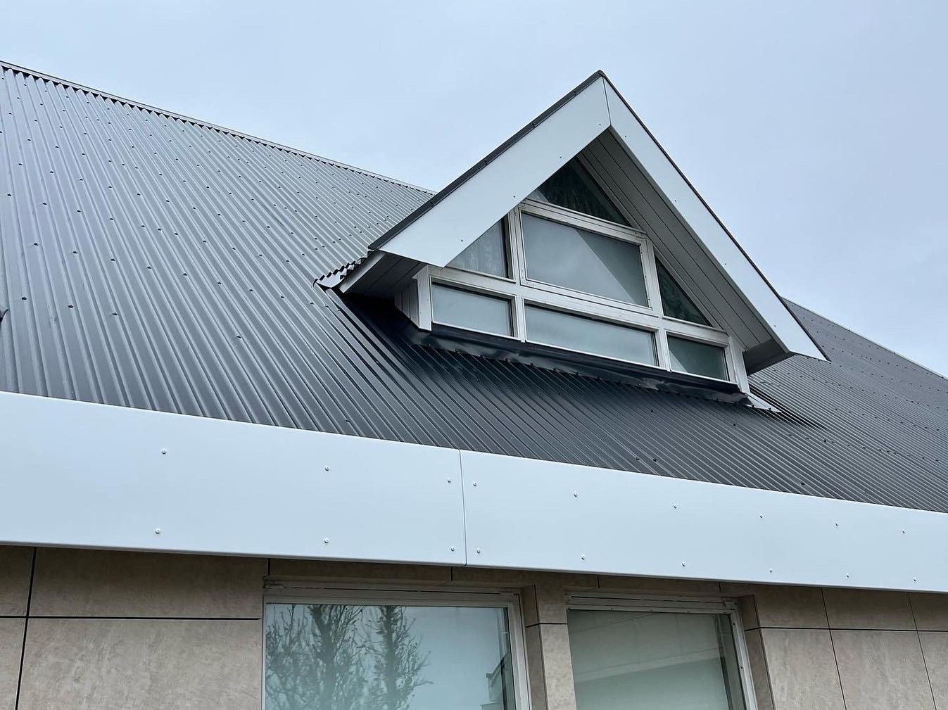 Þak í Keflavík með svartri báru, hvítum þakkanti og hvítum flasningum